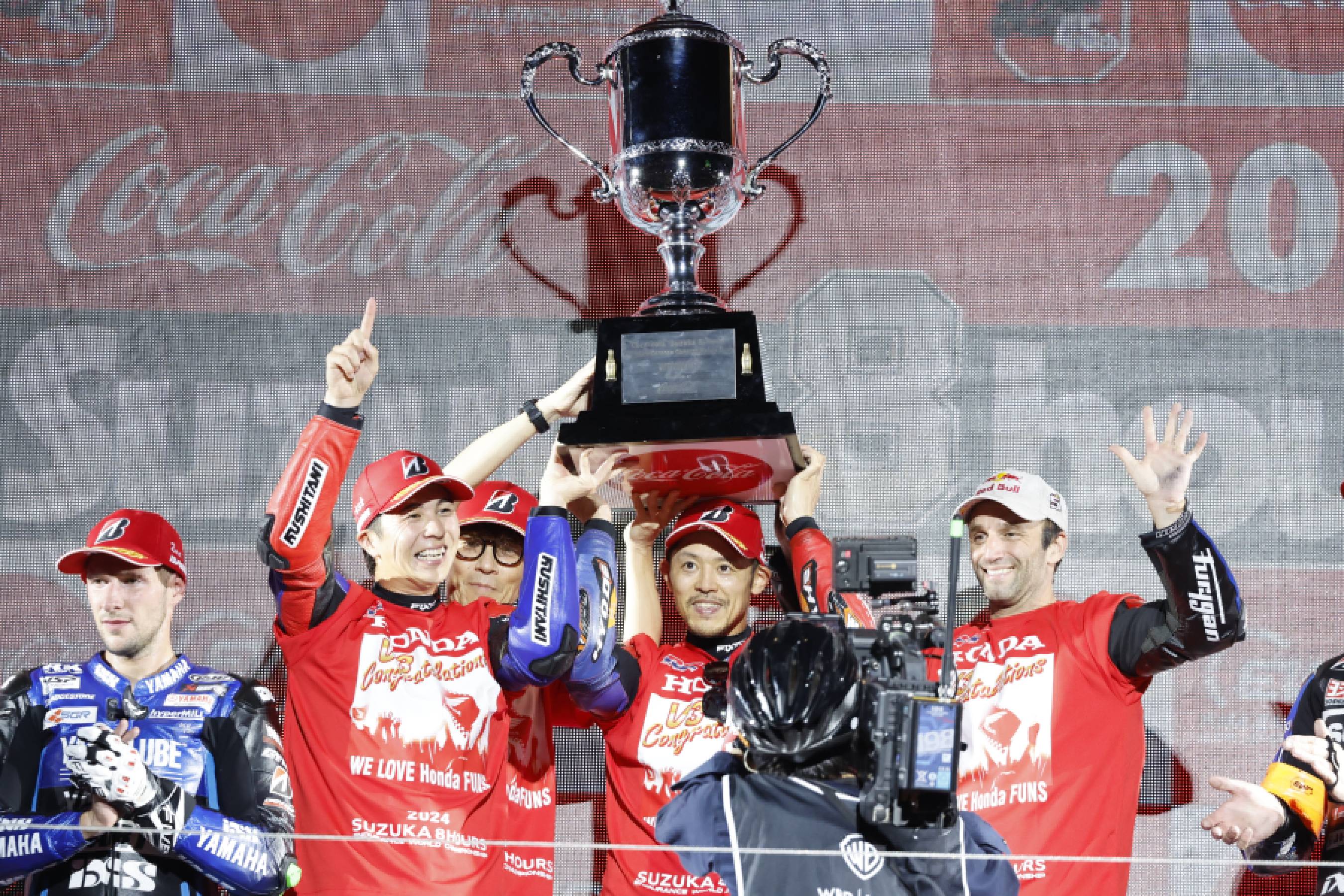 Riders of Team HRC with Japan Post holding the winner's trophy: Teppei Nagoe, Takumi Takahashi, Johann Zarco (from left)